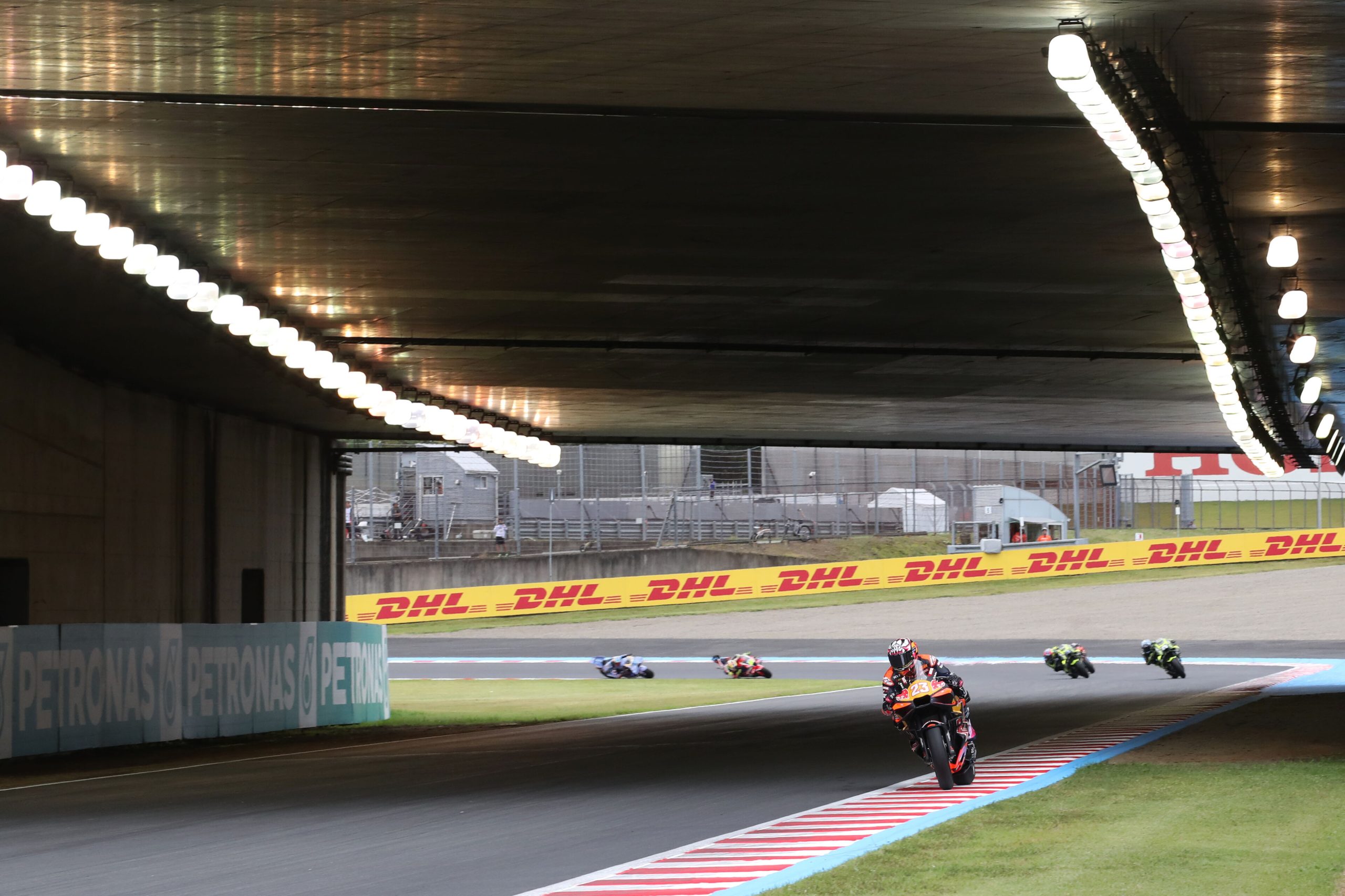MotoGP motosikletleri Motegi pistinde köprü altından geçerken